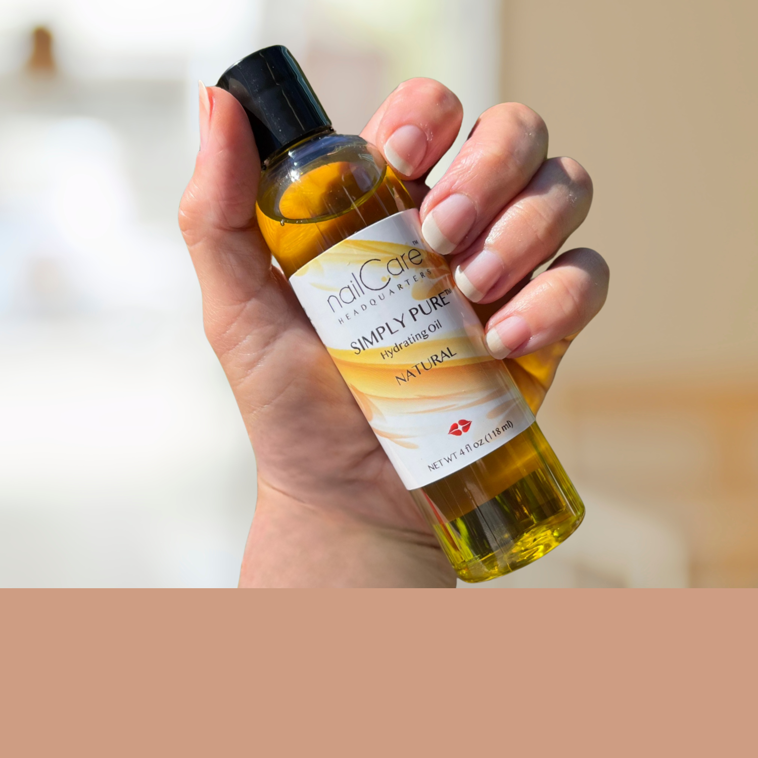 Hand holding a bottle of Simply Pure nail cuticle and body oil with a blurred background