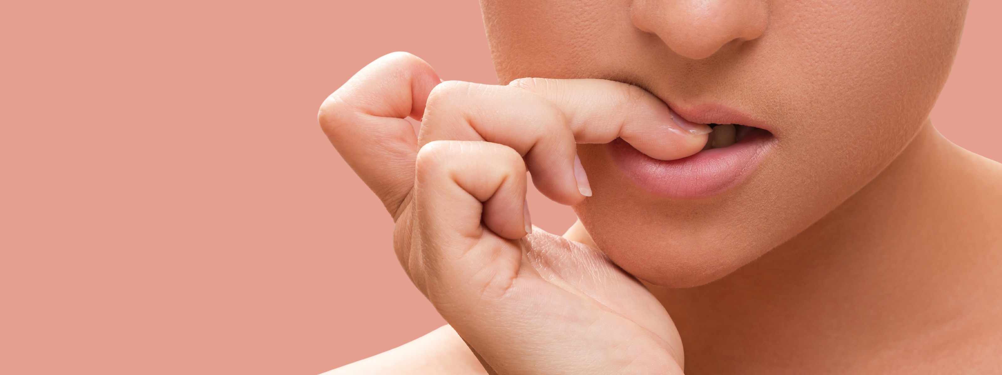 image shows a closeup of someones mouth as they bite down on their nails nervously.