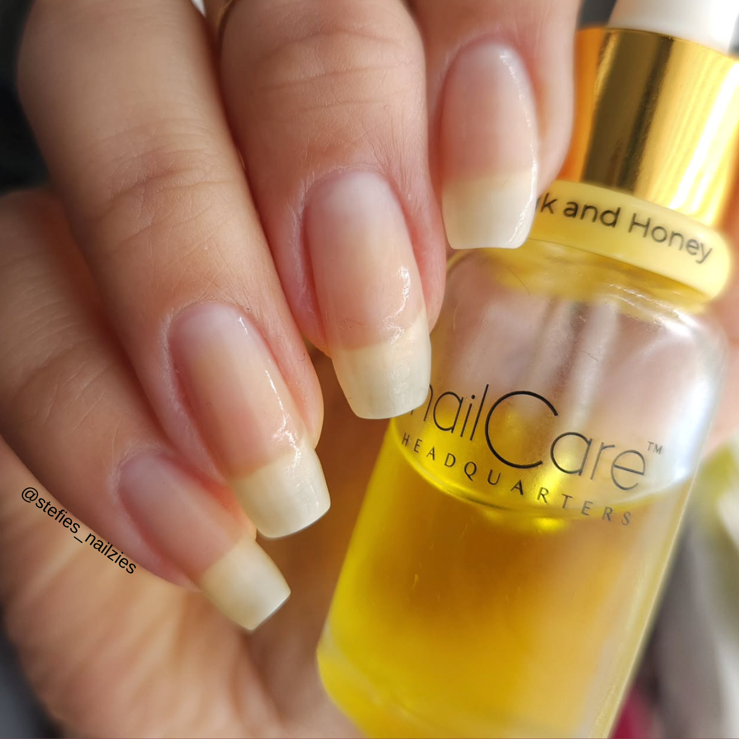 @stefies_nailzies
Photo shows a hand with a long set of nails. the nails look freshly oiled, nourished and strong. 
The hand is holding a dropper bottle of Milk and Honey by Nail Care headquarters 